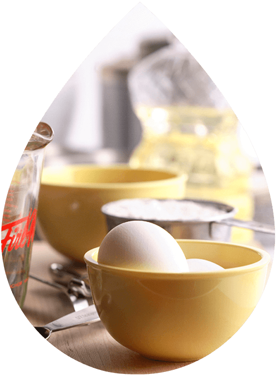 Baking ingredients on a countertop, including eggs, flour, and measuring cups.